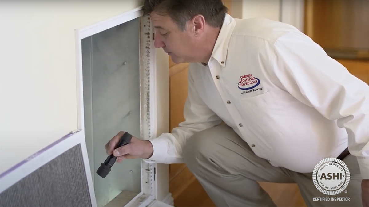 Scott Stegall, one our home inspectors, inspecting an air conditioning vent